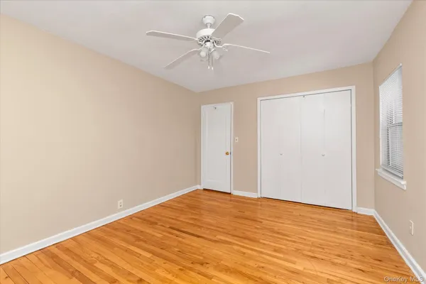 a view of a room with a ceiling fan and wooden floor