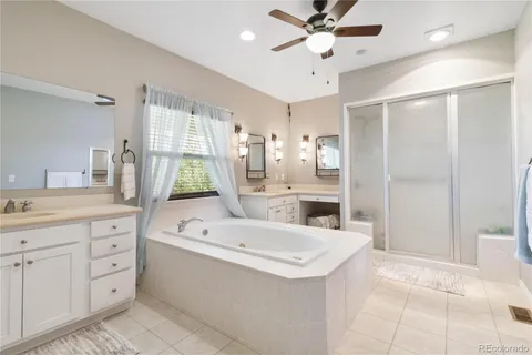a large white kitchen with a large window a sink and stainless steel appliances