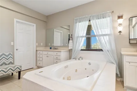 a bathroom with a tub sink and mirror