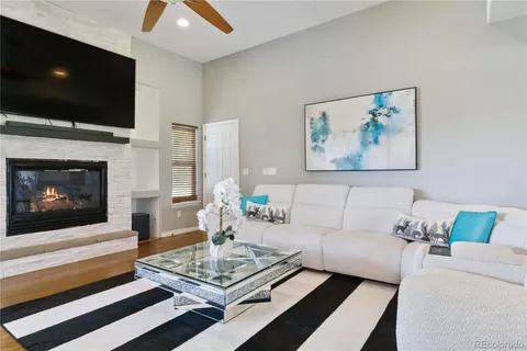 a living room with furniture a flat screen tv and a fireplace