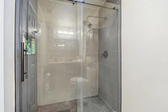 a bathroom with a glass shower door