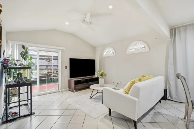 a living room with furniture a flat screen tv and a window
