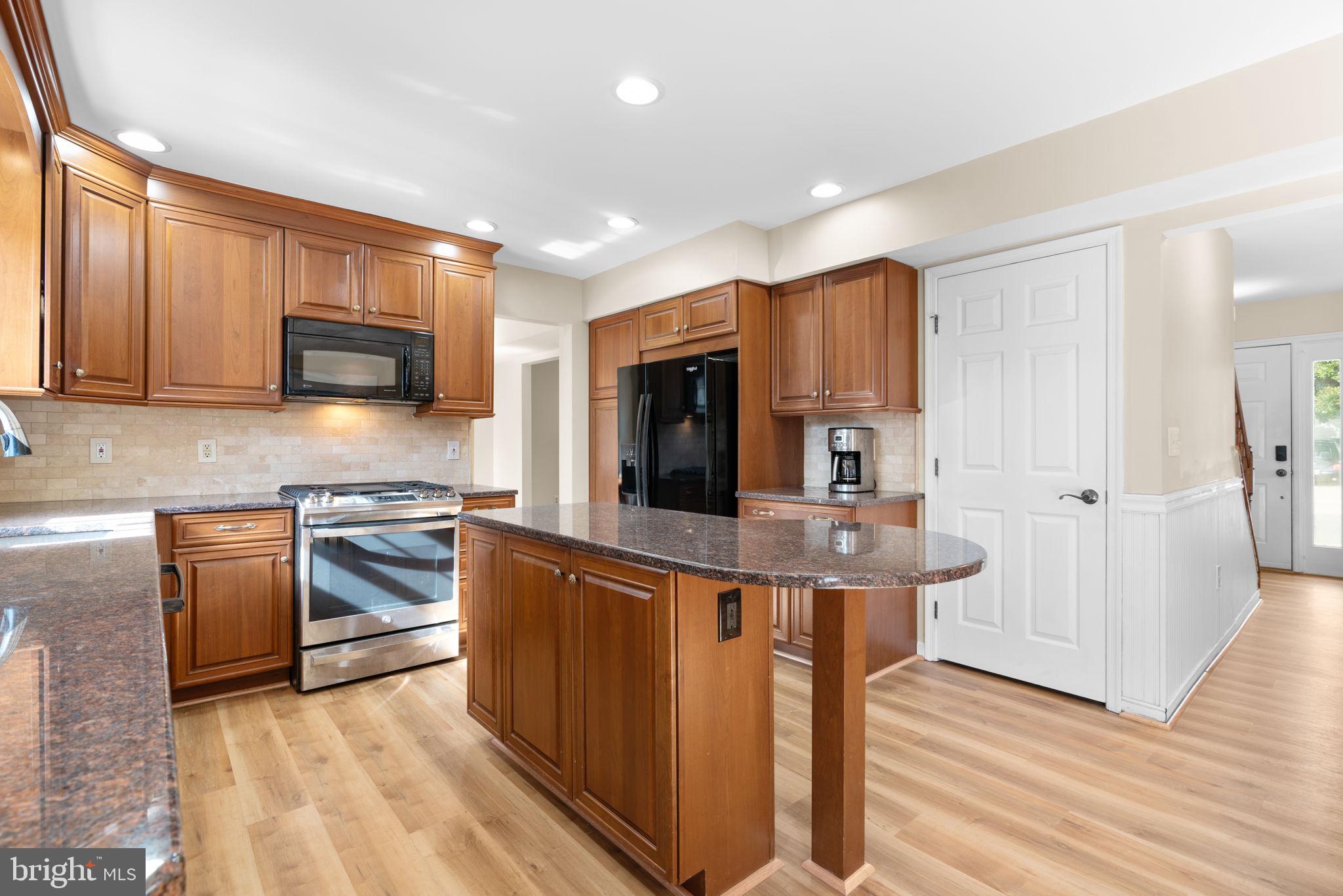 103 Idlewild Road Severna Park, MD 21146 - Photo 11 of 39 a kitchen with stainless steel appliances granite countertop wooden cabinets a refrigerator a stove a sink and dishwasher with wooden floor