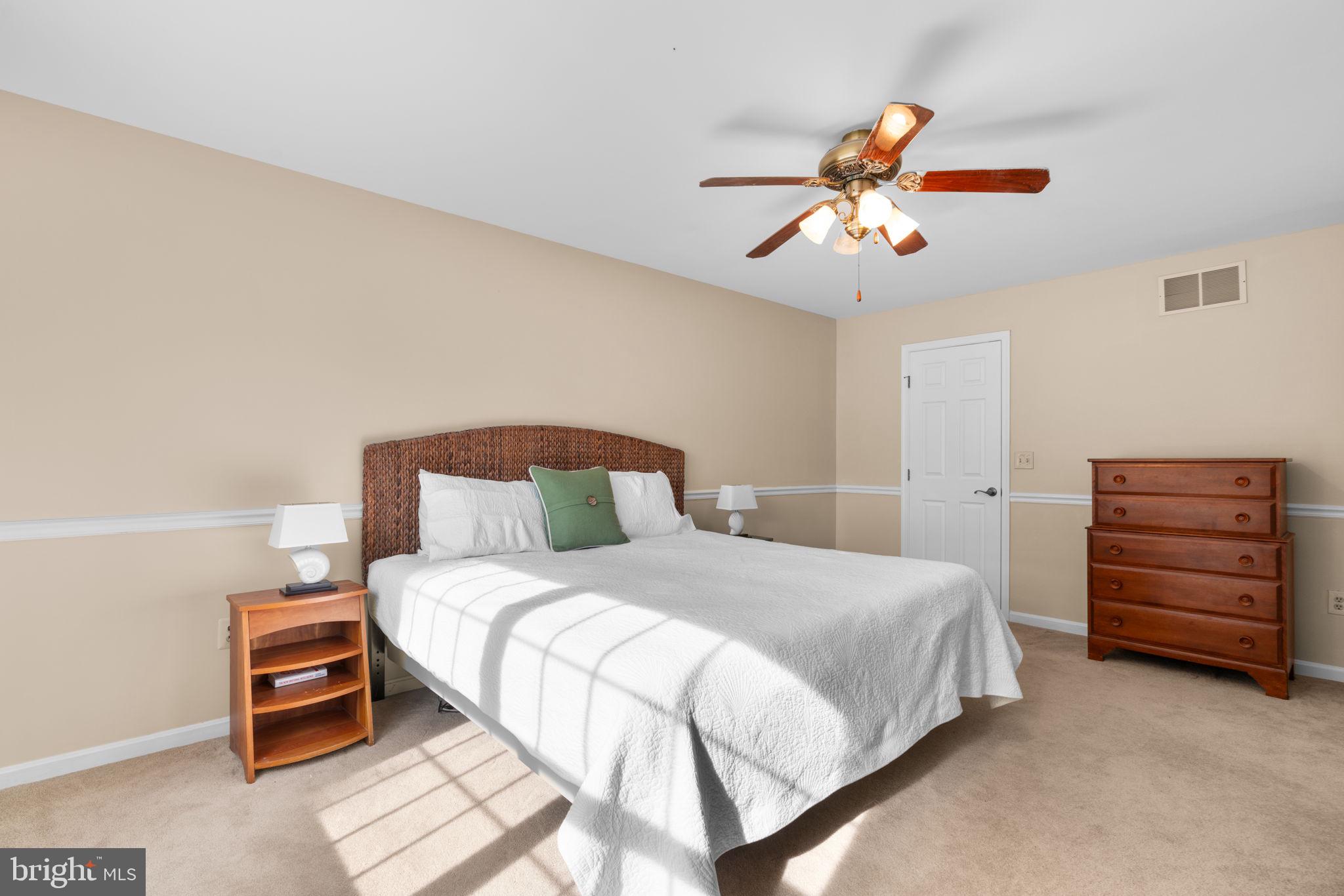 103 Idlewild Road Severna Park, MD 21146 - Photo 17 of 39 a bedroom with a bed a dresser and a chandelier