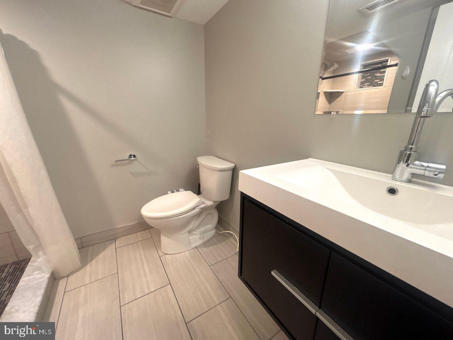 533 Manton Street Philadelphia, PA 19147 - Photo 22 of 22 a bathroom with a sink a toilet and a mirror