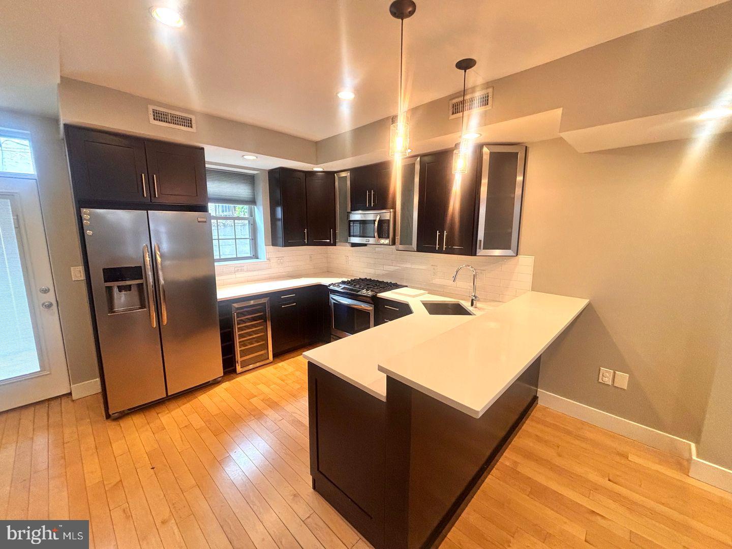533 Manton Street Philadelphia, PA 19147 - Photo 6 of 22 a kitchen with stainless steel appliances granite countertop a sink and a refrigerator
