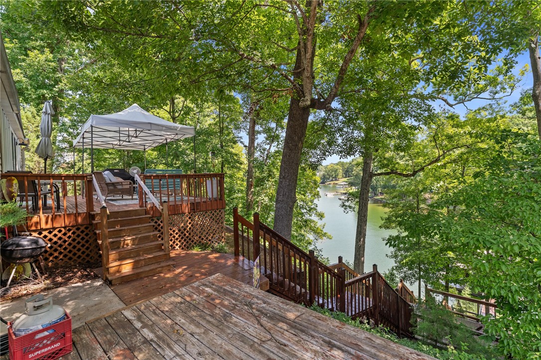 30 Mobleys Bluff Road Abbeville, SC 29620 - Photo 4 of 35 Multi-level wooden decks lead down to serene lakeside views framed by mature forest trees.