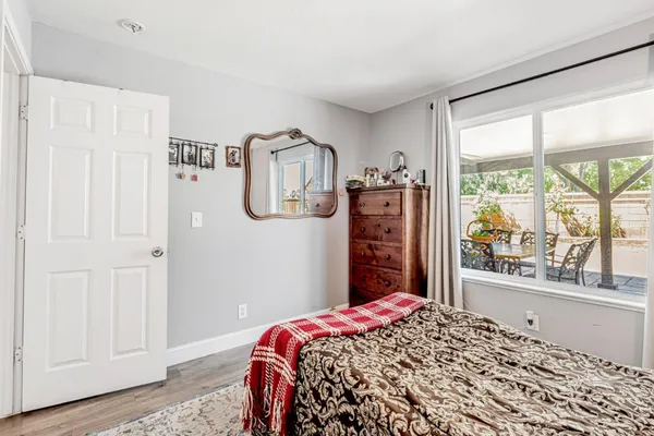 a bedroom with a bed dresser and a large window