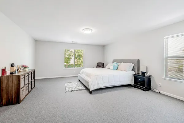 a spacious bedroom with a bed and a window