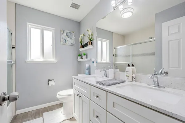 a bathroom with a sink a toilet and a mirror