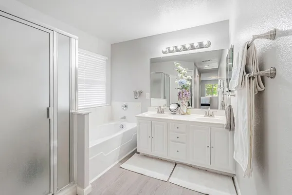 a spacious bathroom with a shower a sink and a mirror
