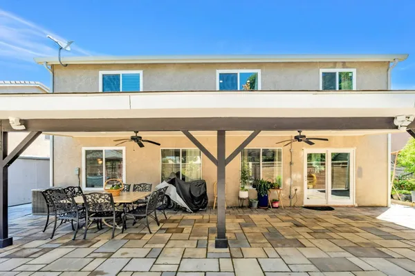 a view of a patio with table and chairs and floor to ceiling window
