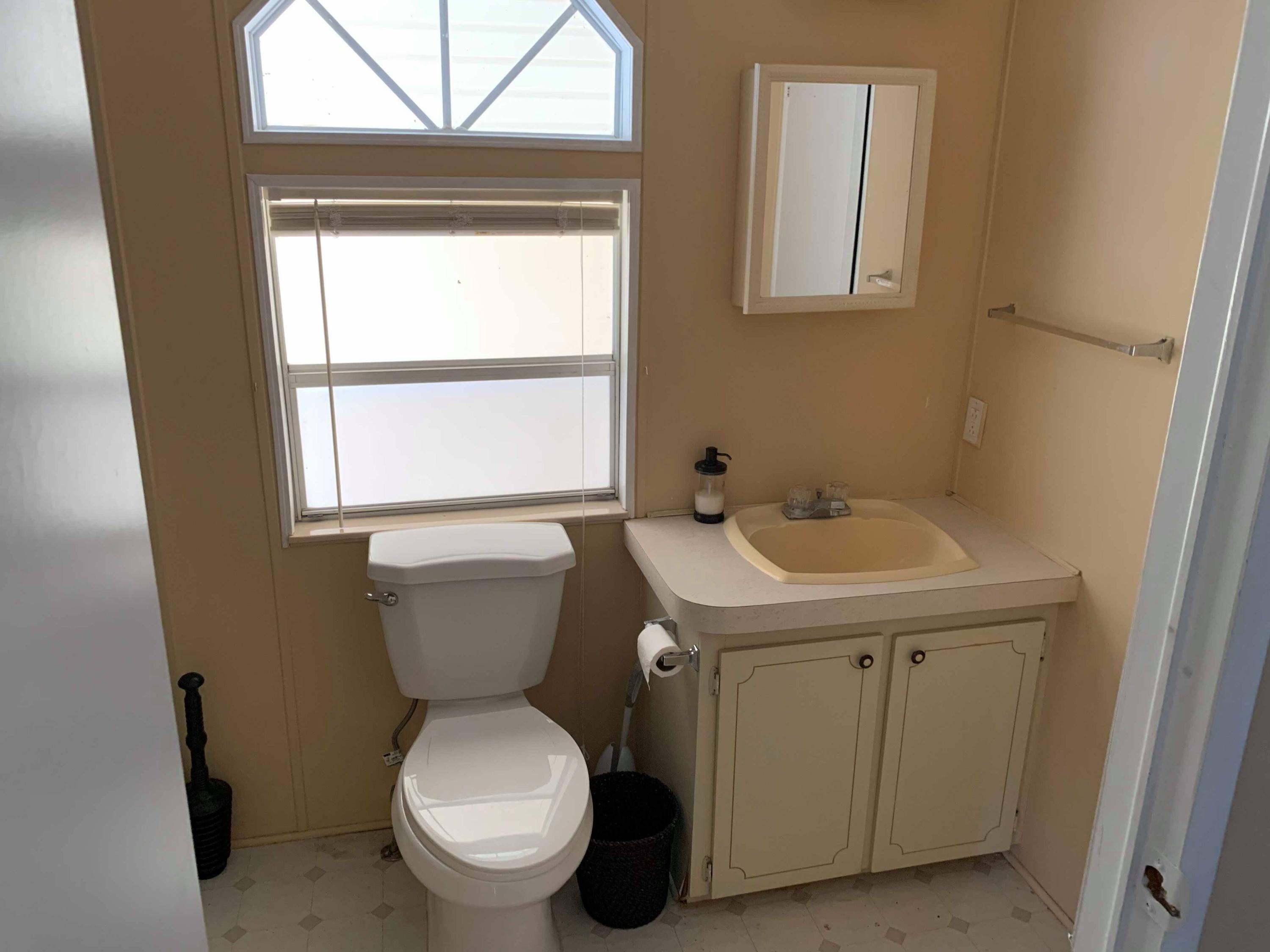 1531 Southwest 65th Avenue Boca Raton, FL 33428 - Photo 14 of 25 a bathroom with a toilet sink and a window