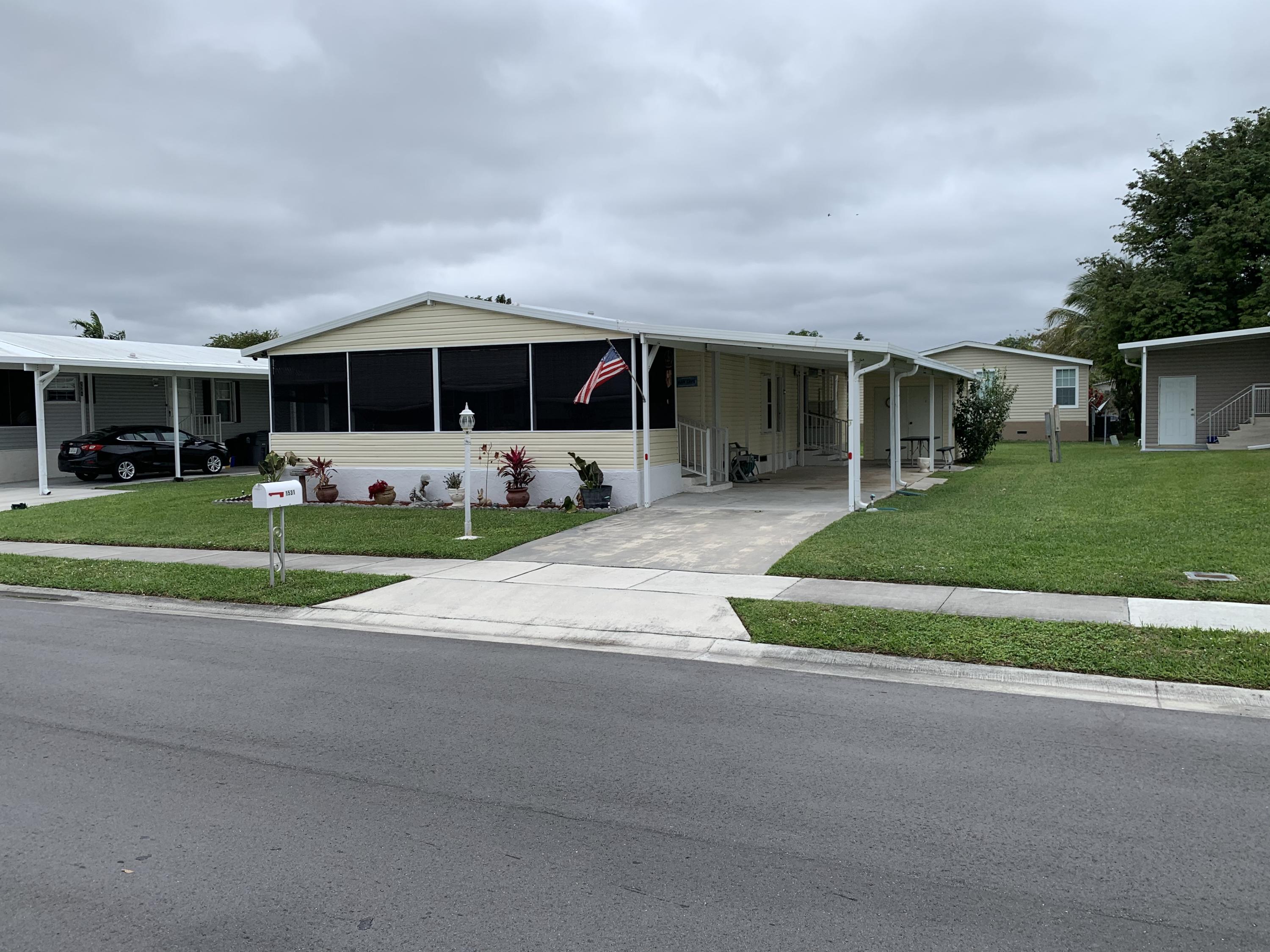 1531 Southwest 65th Avenue Boca Raton, FL 33428 - Photo 2 of 25 a front view of a house with a yard and garage