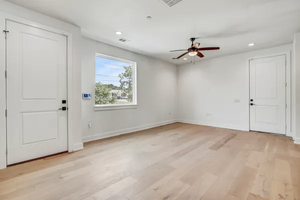 an empty room with fan and windows
