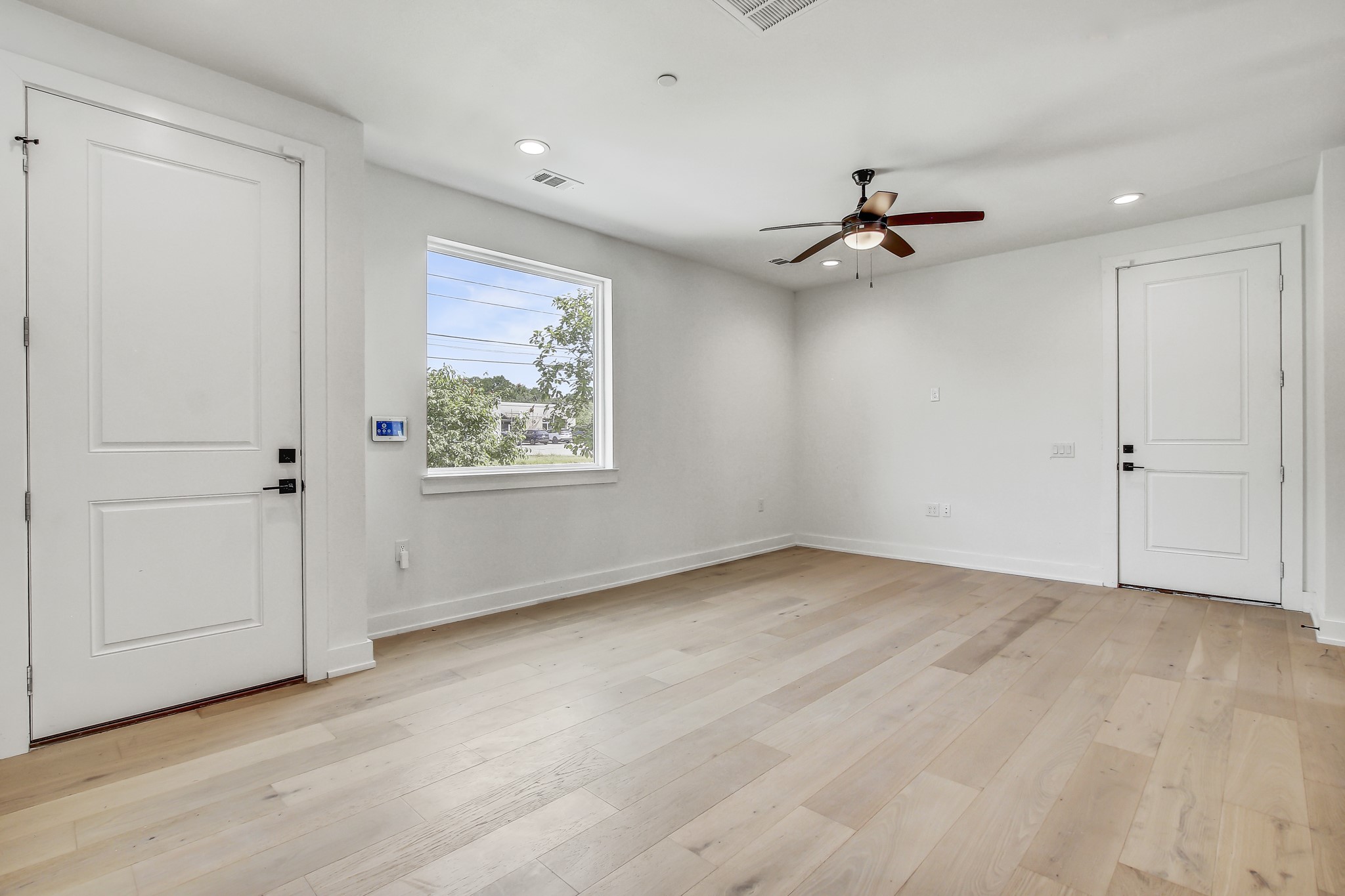 an empty room with fan and windows