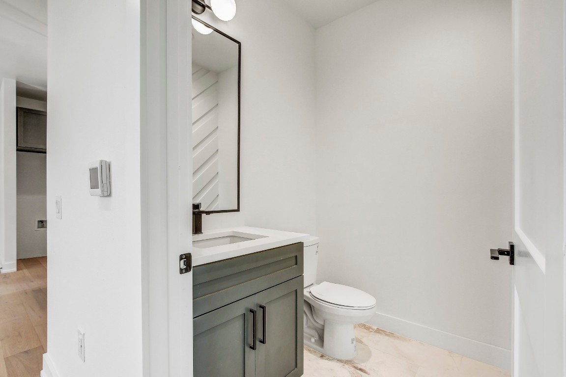4127 East 12th Street, Unit 3 Austin, TX 78721 - Photo 12 of 29 a bathroom with a toilet a sink and mirror