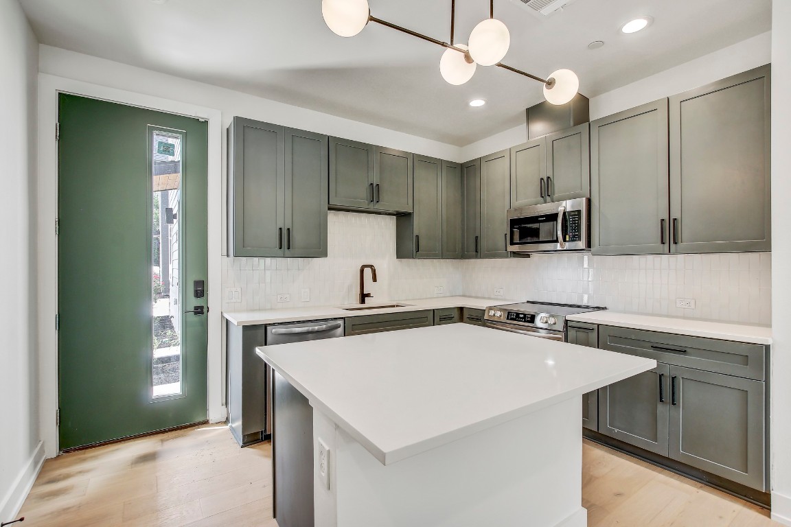 4127 East 12th Street, Unit 3 Austin, TX 78721 - Photo 2 of 29 a kitchen with a sink a stove and cabinets