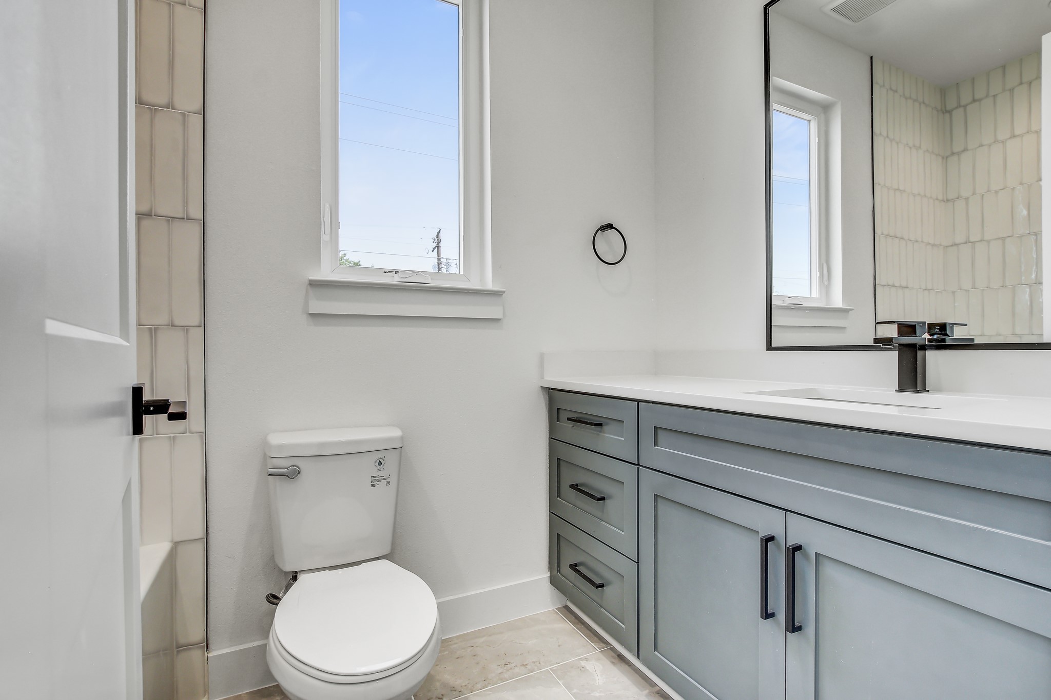 4127 East 12th Street, Unit 3 Austin, TX 78721 - Photo 22 of 29 a bathroom with a sink a toilet and a mirror