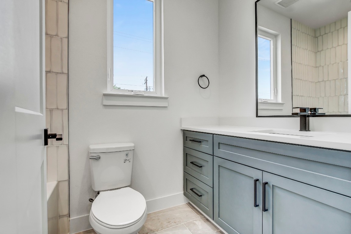 4127 East 12th Street, Unit 3 Austin, TX 78721 - Photo 22 of 29 a bathroom with a sink a toilet and a mirror