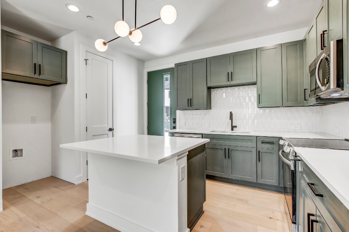 4127 East 12th Street, Unit 3 Austin, TX 78721 - Photo 3 of 29 a kitchen with a sink a stove a refrigerator and cabinets