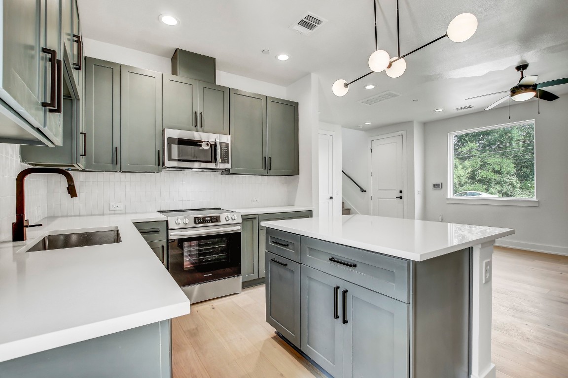 4127 East 12th Street, Unit 3 Austin, TX 78721 - Photo 5 of 29 a kitchen with kitchen island a sink stainless steel appliances and cabinets
