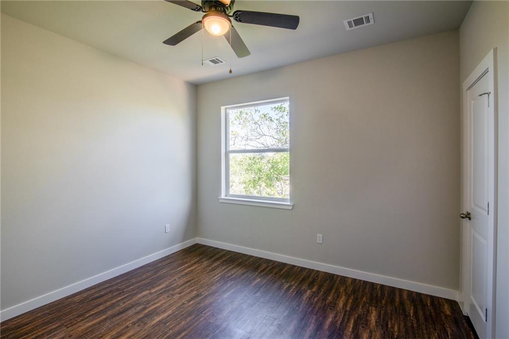 906 Quartz Court, Unit 601 Cedar Park, TX 78613 - Photo 10 of 15 an empty room with wooden floor fan and windows