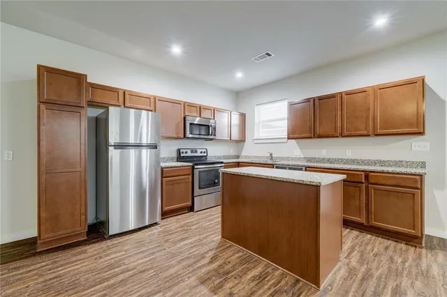 a view of kitchen with sink a microwave and wooden floor