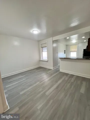 an empty room with a fireplace and wooden floor