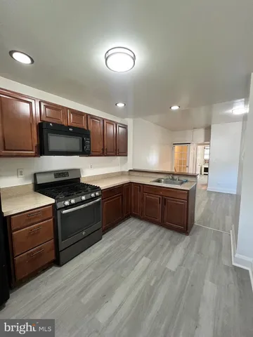 a kitchen with stainless steel appliances kitchen island granite countertop a stove a sink and a refrigerator