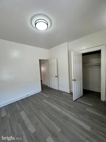 an empty room with wooden floor and closet