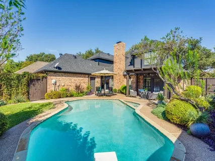 a view of a house with swimming pool and sitting area