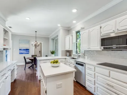 a kitchen with a sink a stove a dining table and chairs
