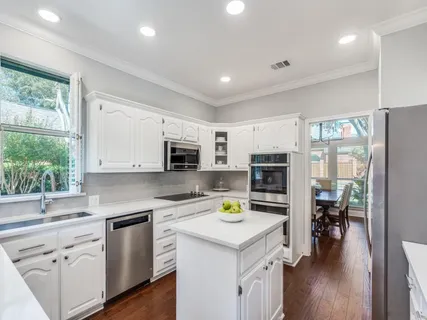 a kitchen with a sink a counter top space stainless steel appliances and a window