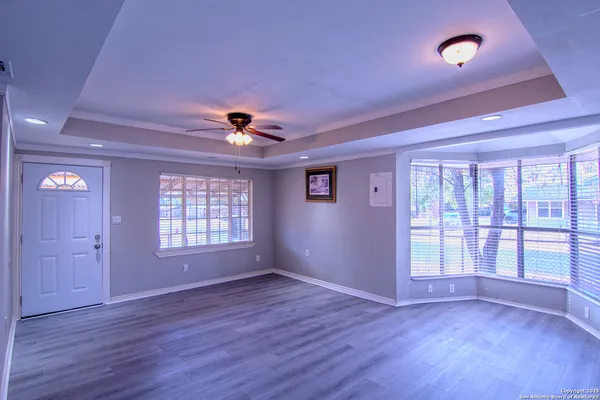 a view of an empty room with a window and wooden floor