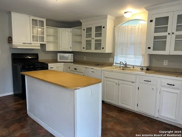 a kitchen with a refrigerator and table chair
