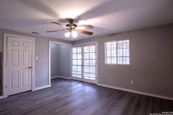 a view of a room with wooden floor and a ceiling fan