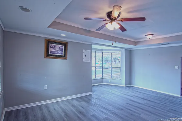a view of an empty room with a window and wooden floor