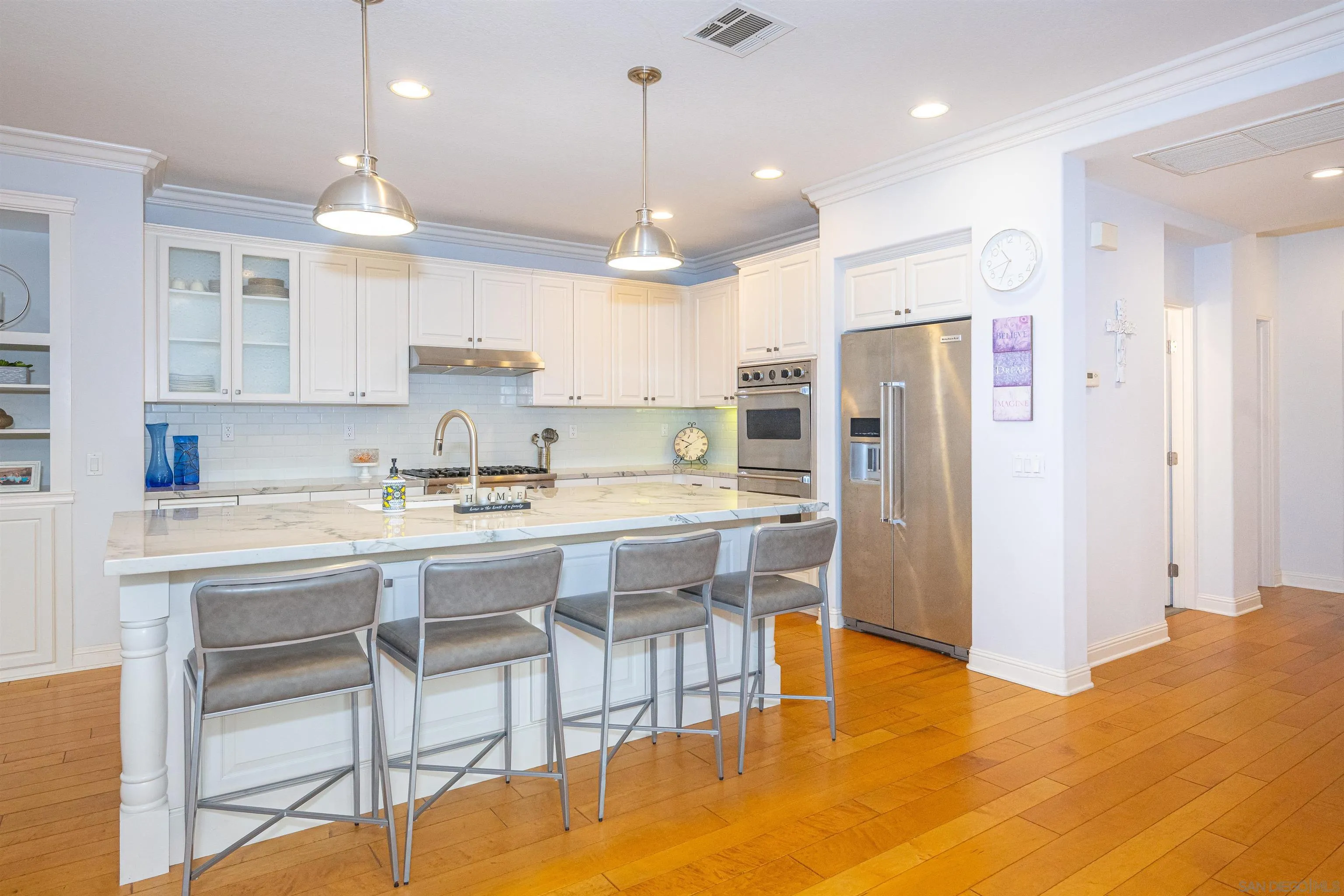 1540 Weatherly Road Carlsbad, CA 92011 - Photo 41 of 58 a kitchen with stainless steel appliances granite countertop a refrigerator a sink dishwasher a dining table and chairs with wooden floor