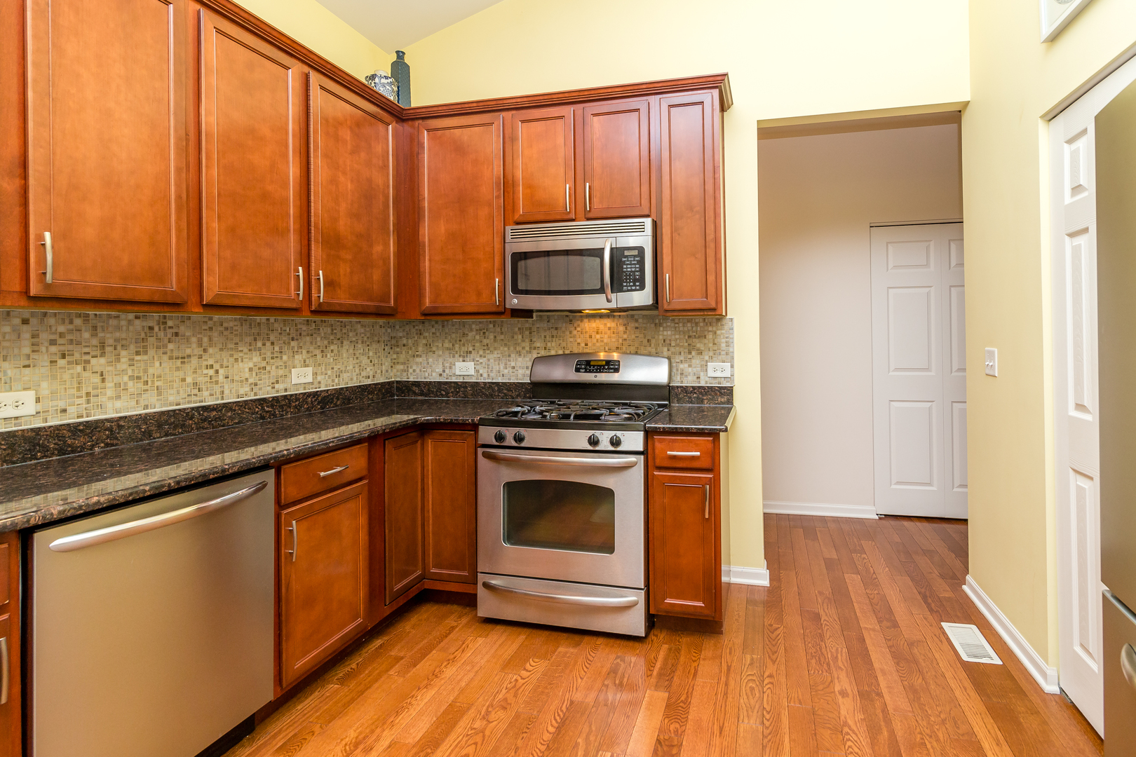 976 Oak Ridge Boulevard Elgin, IL 60120 - Photo 11 of 39 a kitchen with granite countertop wooden floors and stainless steel appliances