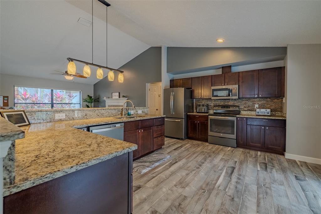 222 Halton Circle Seffner, FL 33584 - Photo 16 of 57 a kitchen with stainless steel appliances kitchen island granite countertop a stove a sink and a refrigerator