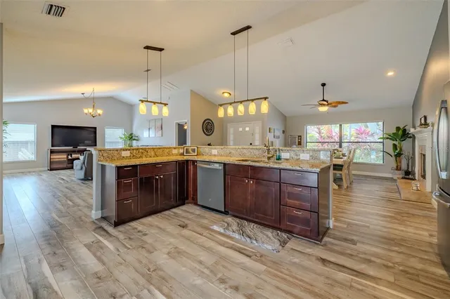 a living room with furniture kitchen view and a chandelier
