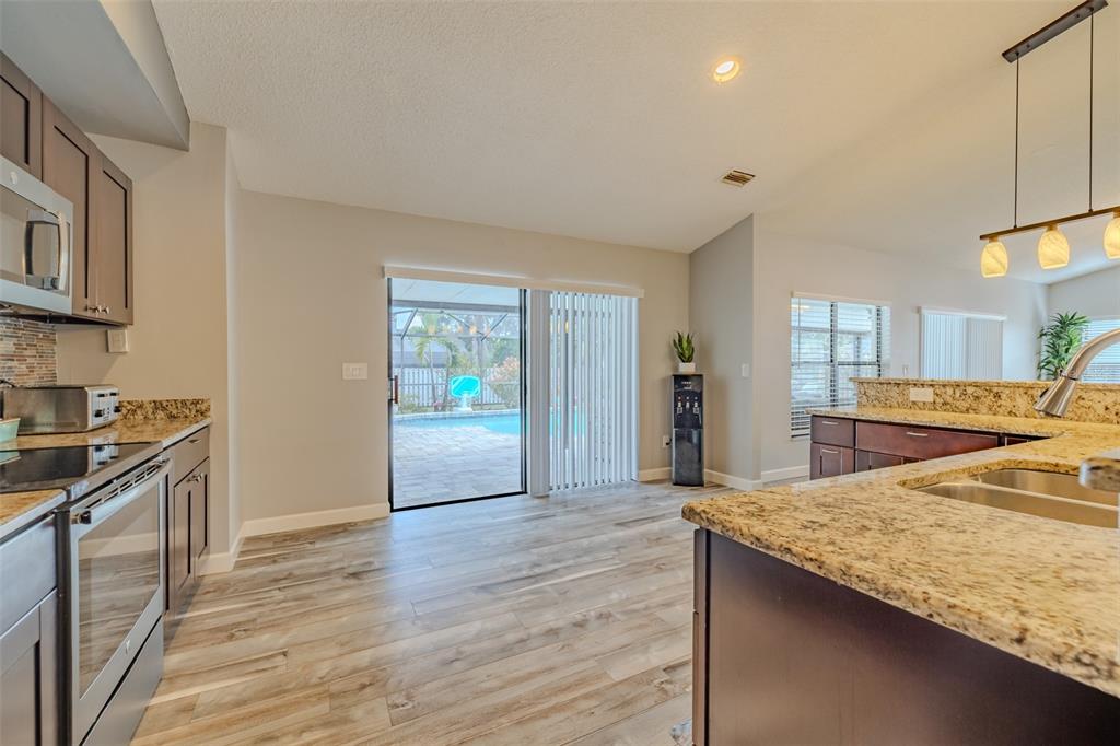 222 Halton Circle Seffner, FL 33584 - Photo 19 of 57 a kitchen with granite countertop a stove and a wooden floors