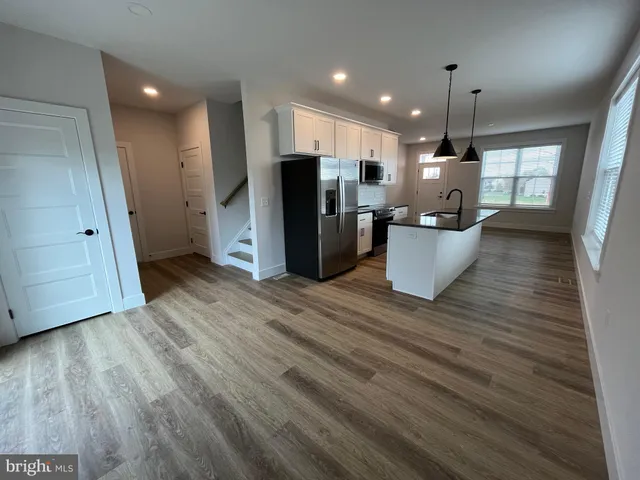 a view of kitchen with refrigerator microwave and stove