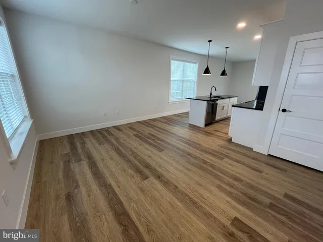 a kitchen with cabinets and wooden floor