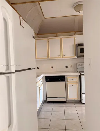 a kitchen with white cabinets and white appliances