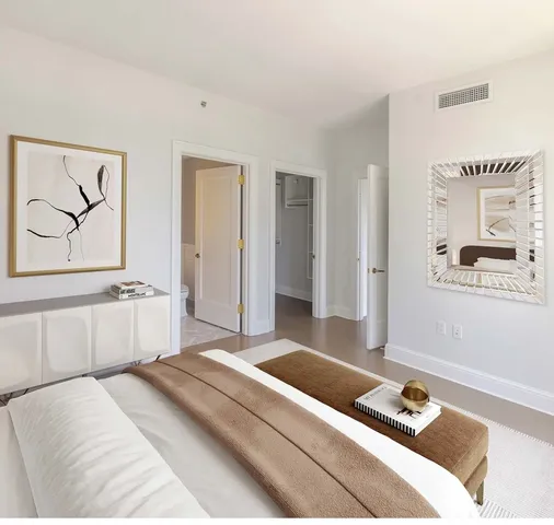 a bedroom with a bed and a painting on the wall