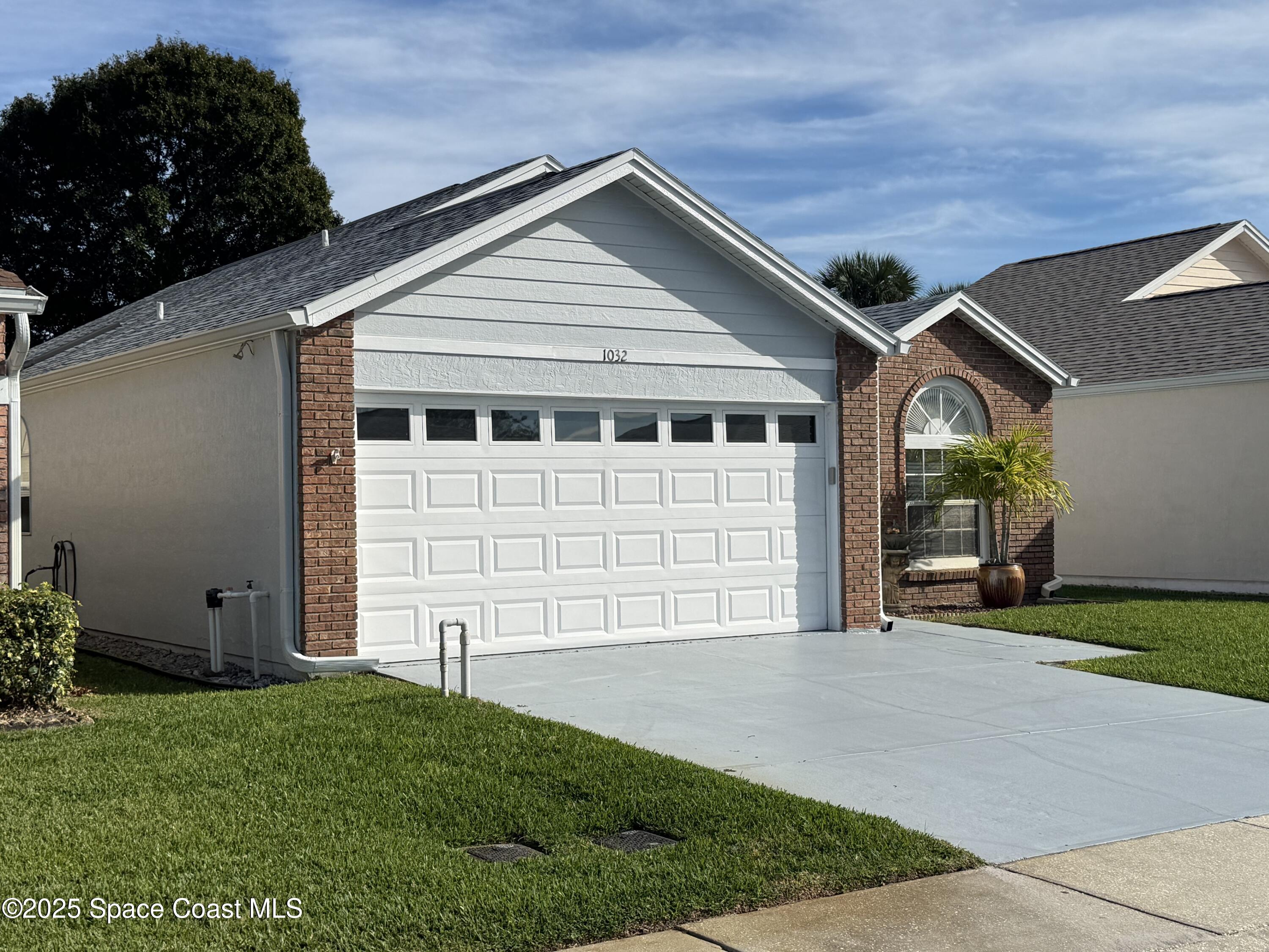1032 South Fork Circle Melbourne, FL 32901 - Photo 3 of 35 a front view of a house with a yard and garage