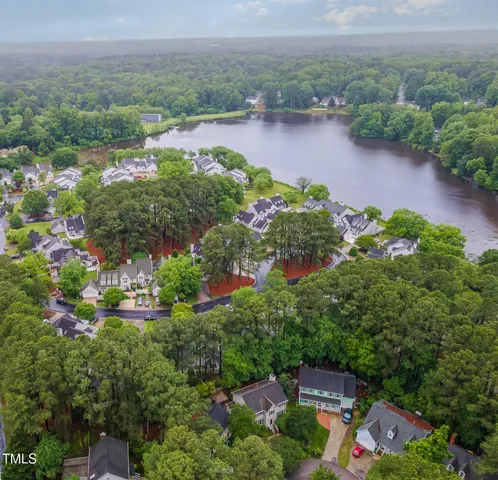 an aerial view of a house with a garden and lake view