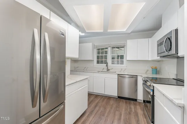 a kitchen with stainless steel appliances granite countertop a refrigerator and a stove top oven